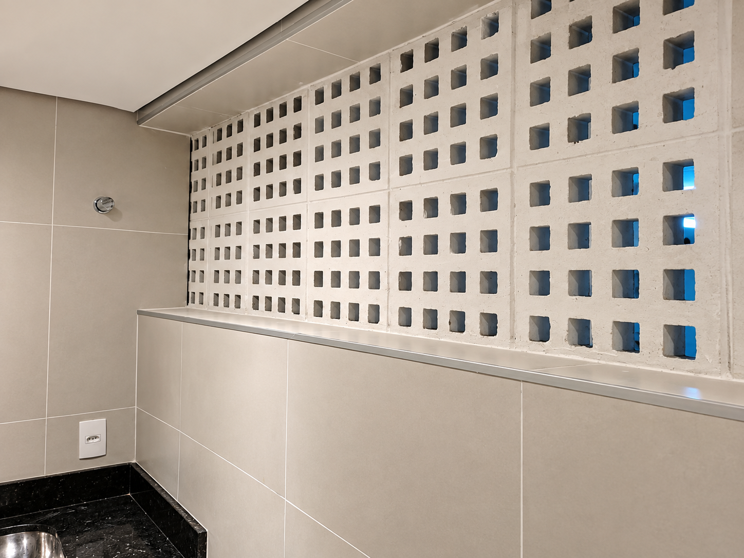 Acabamento interno com revestimento cerâmico e elementos vazados executado pela JM Construções